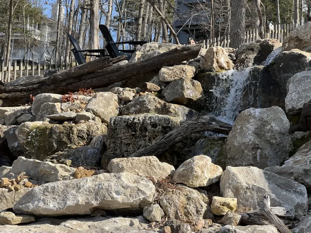 Pondless waterfall installation with moss rock boulders